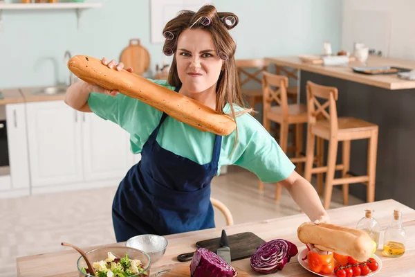 Aggressive young housewife in kitchen — Stock Photo, Image