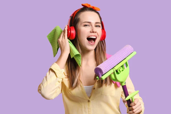 Young singing housewife on color background