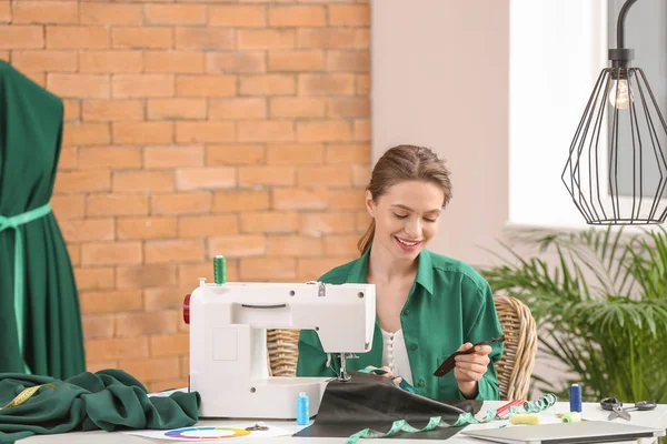 Giovane donna che cuce vestiti in atelier — Foto Stock