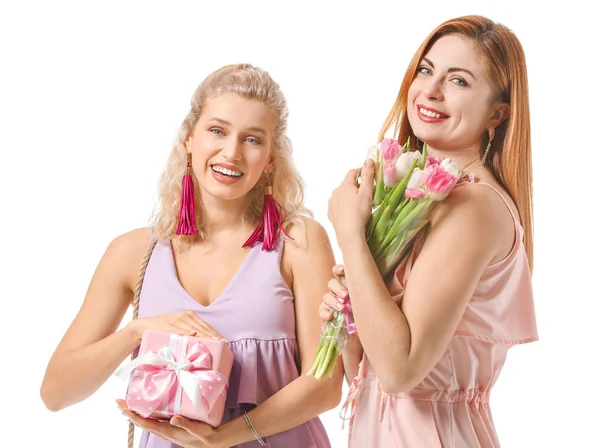 Vackra unga kvinnor med gåvor på vit bakgrund. Internationella kvinnodagen firas — Stockfoto