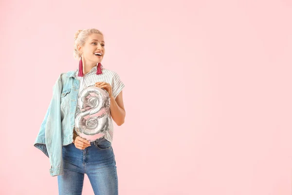 Beautiful young woman with balloon in shape of figure 8 on color background. International Women's Day celebration — Stock Photo, Image