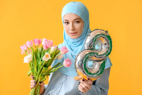 Gyönyörű muszlim nő léggömbbel alakja 8 és virágok a színes háttér. Nemzetközi nőnapi ünneplés — Stock Fotó