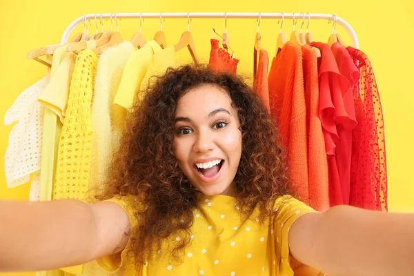 Styliste afro-américain prenant selfie près de rack avec des vêtements modernes — Photo