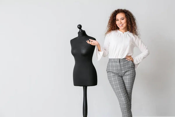 African-American stylist near mannequin against light wall — Stock Photo, Image