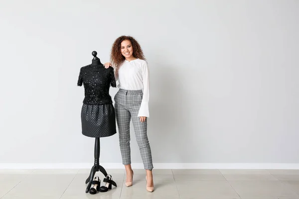 African-American stylist near mannequin against light wall — 스톡 사진