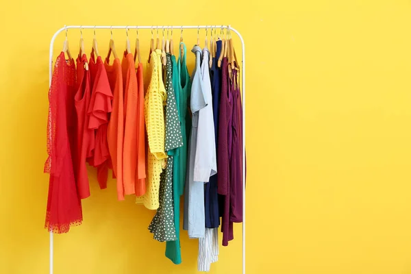 Bastidor con ropa moderna cerca de la pared de color — Foto de Stock