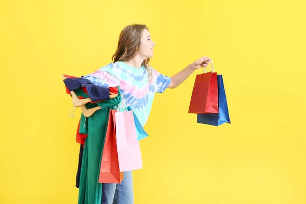 Styliste féminine avec sacs à provisions sur fond de couleur — Photo