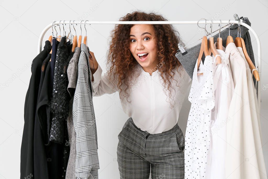 African-American stylist near rack with modern clothes