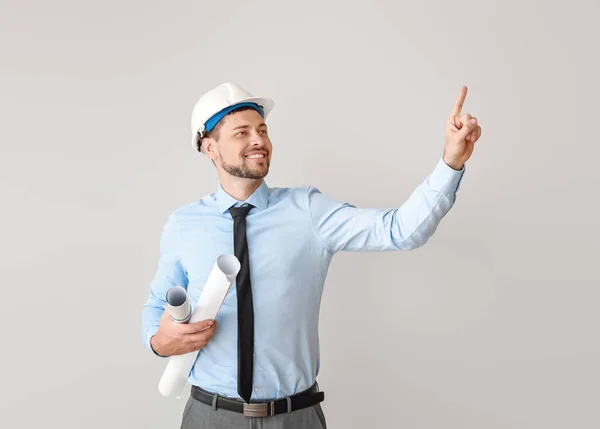 Ingeniero masculino mostrando algo sobre fondo claro —  Fotos de Stock