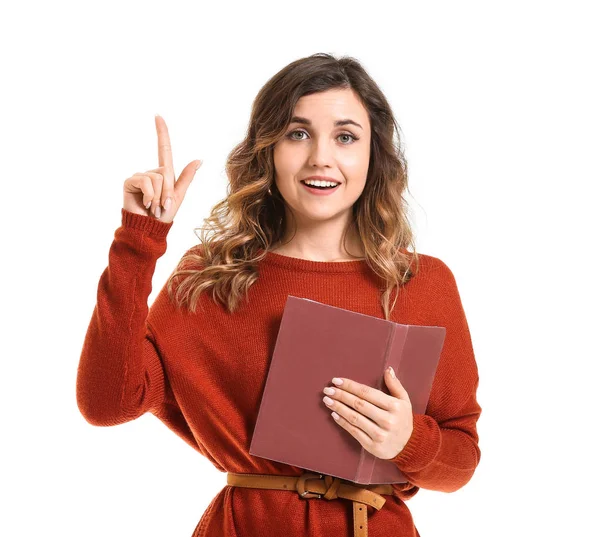 Beautiful young woman with book and raised index finger on white background — Stock Photo, Image