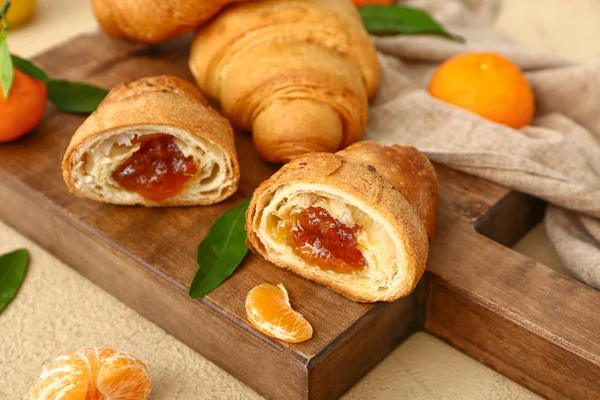 Board with tasty sweet croissants on table — Stock Photo, Image