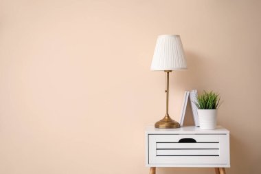 Renk duvarının yanında lamba ve dekor olan masa