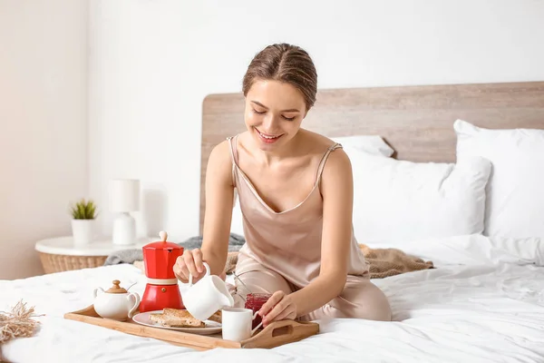 Reggel gyönyörű fiatal nő reggelizik az ágyban — Stock Fotó