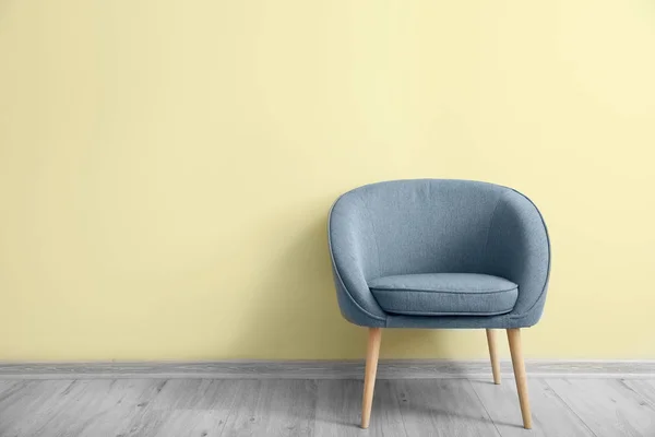 Stylish armchair near color wall in room — Stock Photo, Image