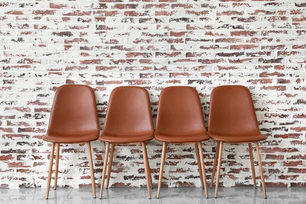 방 안의 벽돌 벽 근처에 있는 멋진 의자들 — 스톡 사진