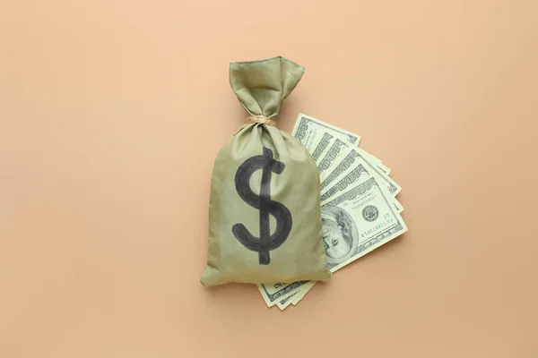 Сумка с деньгами и долларовыми банкнотами на цветном фоне — стоковое фото