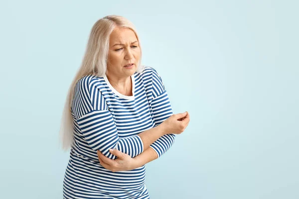 Senior woman suffering from Parkinson syndrome on color background — Stock Photo, Image