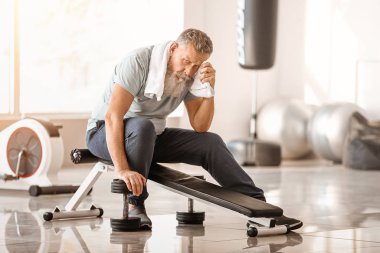 Sportif yaşlı adam beden eğitiminden sonra dinleniyor.