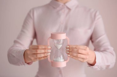 Arka planda kum saati olan kadın, yakın plan. Zaman yönetimi kavramı