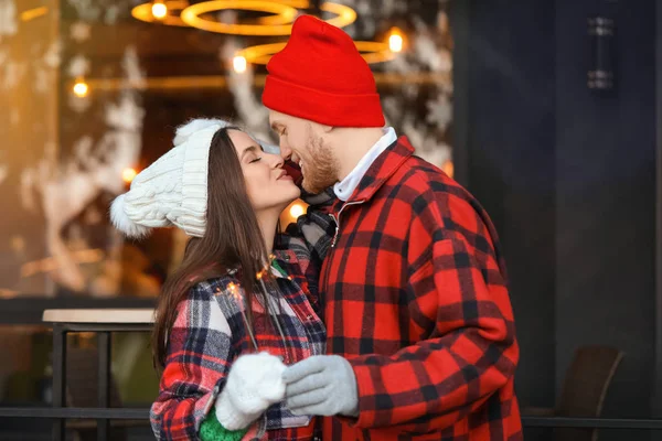 Happy young couple with Christmas sparklers outdoors on winter day — Stock Photo, Image