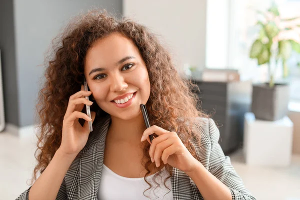 Fiatal afro-amerikai üzletasszony beszél telefonon az irodában — Stock Fotó