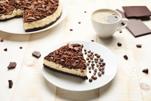 Ízletes csokoládés sajttorta kávéval az asztalon — Stock Fotó
