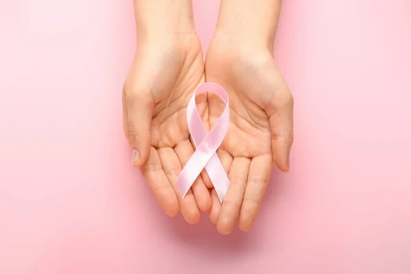 Female hands with pink ribbons on color background. Cancer awareness concept — Stock Photo, Image