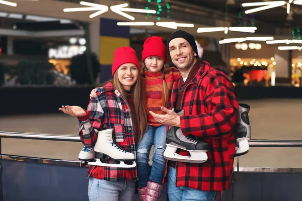 Happy family with ice skates near rink — Stock Photo, Image