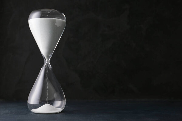 Hourglass on dark background. Time management concept
