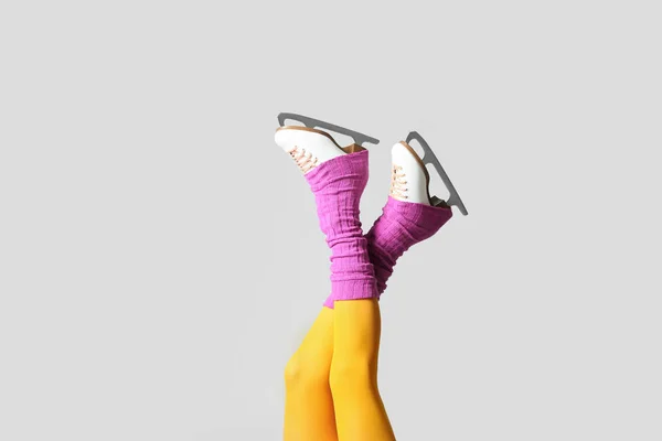 Young woman in ice skate shoes on grey background — Stock Photo, Image