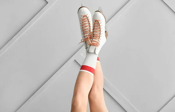 Ung kvinna i skridsko skor på grå bakgrund — Stockfoto