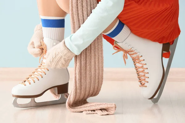 Young woman tying laces on ice skate shoes indoors — Stock Photo, Image