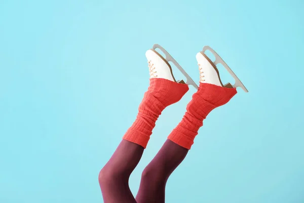 Young woman in ice skate shoes on color background — Stock Photo, Image