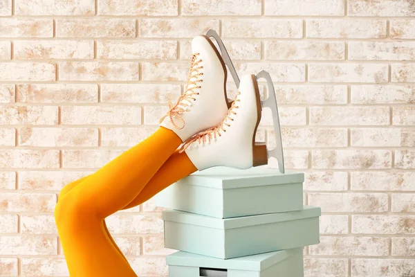 Ung kvinna i skridsko skor och med lådor på tegel bakgrund — Stockfoto
