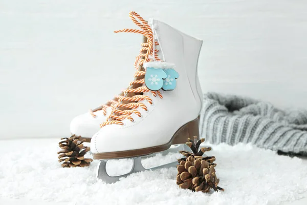 Ice skate shoes with snow and cones on white background — Stock Photo, Image