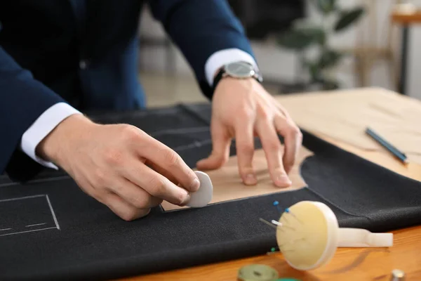 Young tailor working at table in atelier, closeup — Stock Photo, Image