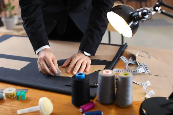 Young tailor working at table in atelier — Stock Photo, Image