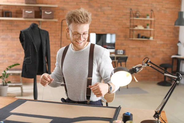 Young tailor working at table in atelier — Stock Photo, Image