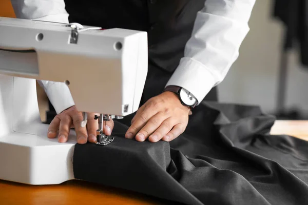 Joven sastre masculino trabajando en la máquina de coser en el taller — Foto de Stock