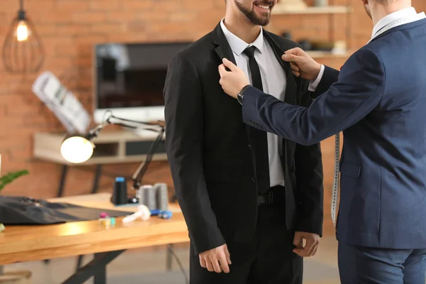 Alfaiate masculino fazendo medições do cliente no atelier — Fotografia de Stock