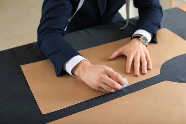 Young tailor working at table in atelier, closeup — Stock Photo, Image