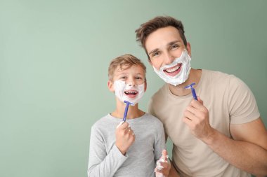 Babası ve küçük oğlu renk geçmişine karşı traş oluyorlar.