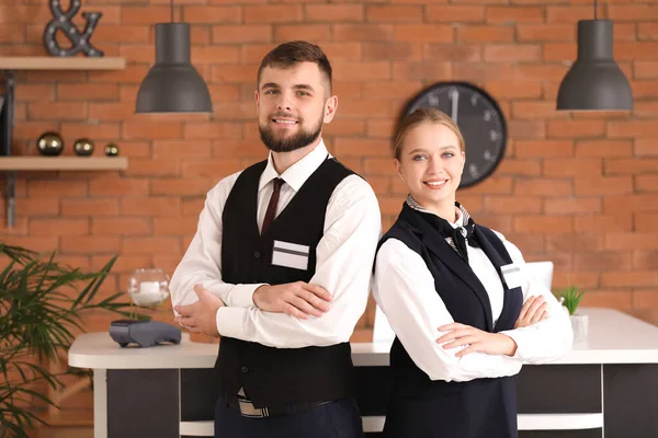 Manliga och kvinnliga receptionister nära skrivbord i hotel — Stockfoto