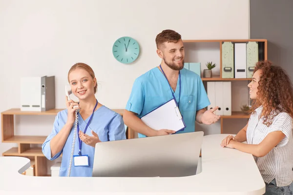 Recepcionistas masculinas e femininas trabalhando na mesa na clínica — Fotografia de Stock