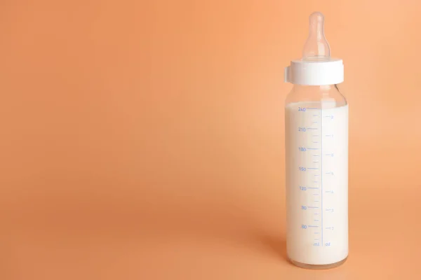 Bebek için arka planda bir şişe süt — Stok fotoğraf