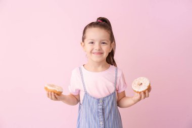 Renkli donutları olan komik küçük bir kız.
