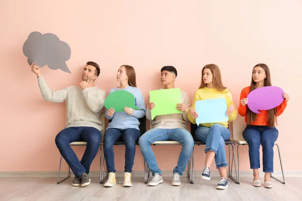 Grupo de jóvenes con burbujas de habla en blanco cerca de la pared de color — Foto de Stock