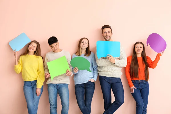 Skupina mladých lidí s prázdnou řeč bubliny na barevném pozadí — Stock fotografie