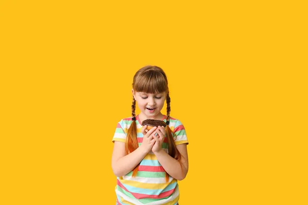 Rolig liten flicka med munk på färg bakgrund — Stockfoto