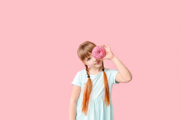 Funny little girl with donut on color background — Stock Photo, Image